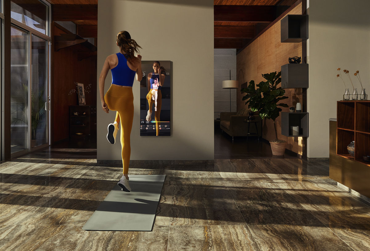 A photo of a woman using the Mirror in her home.