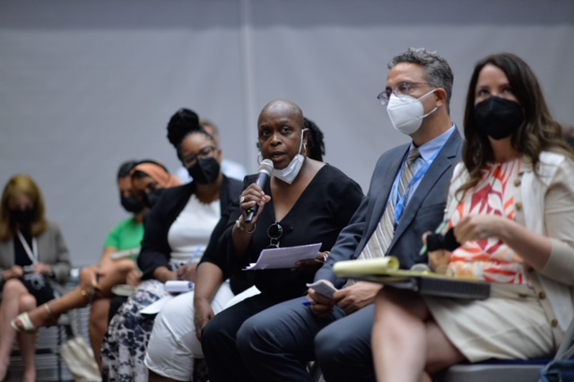 Angela Burton speaking into a microphone.