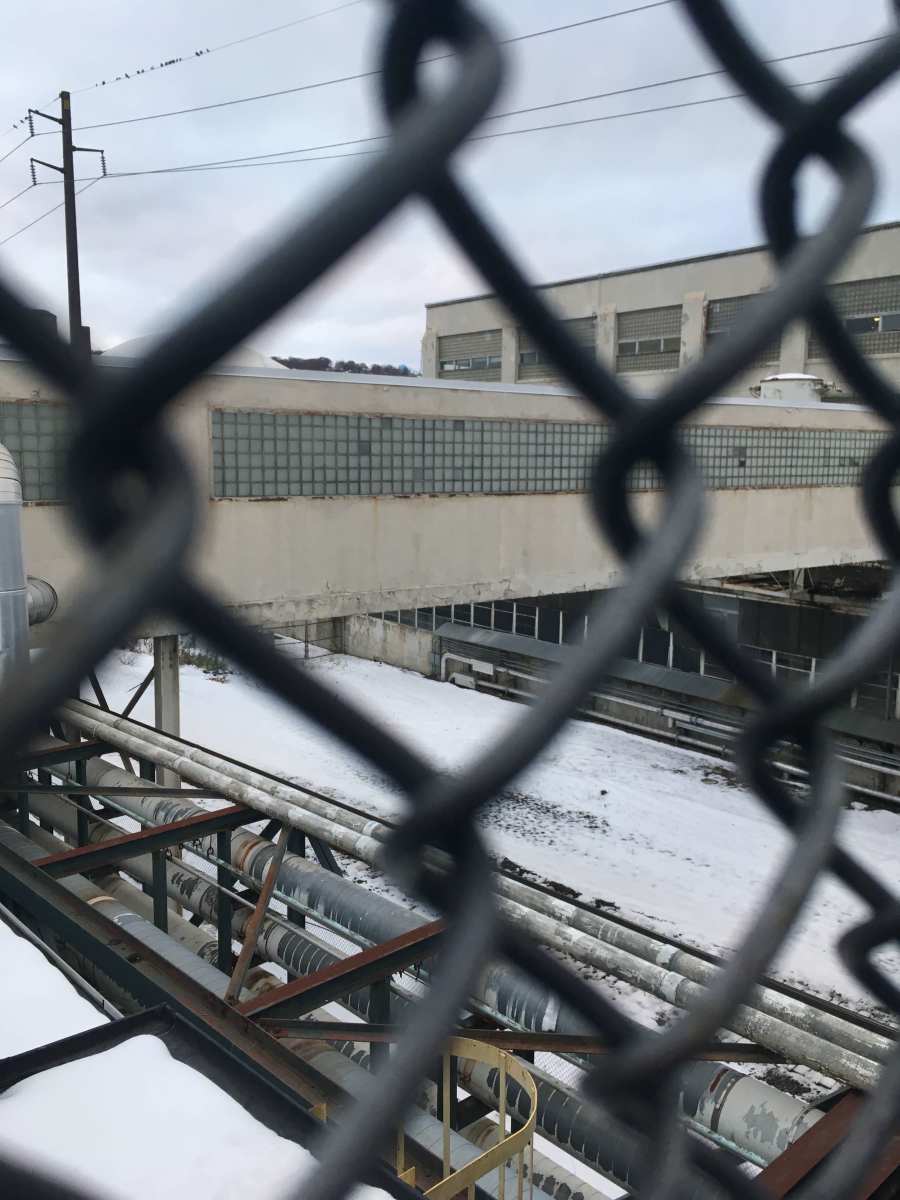 A shot of a building from inside a chain link fence.