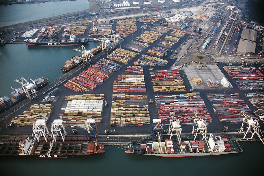 A port with container ships and neatly organized, colorful containers.