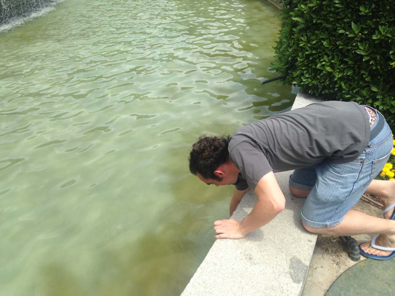 A person reaches into a river.