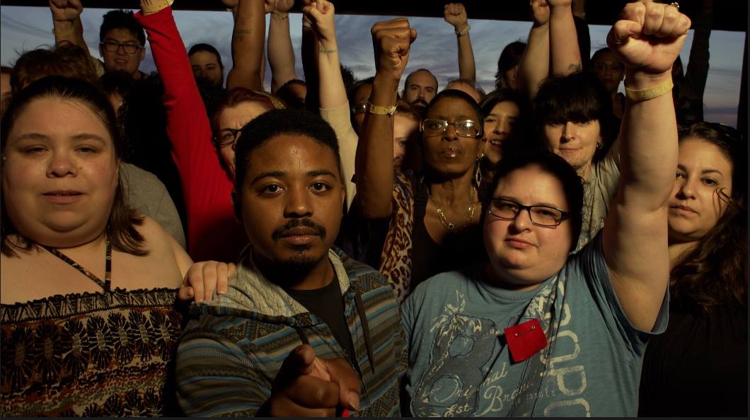 A photo of a group of students with fists raised.