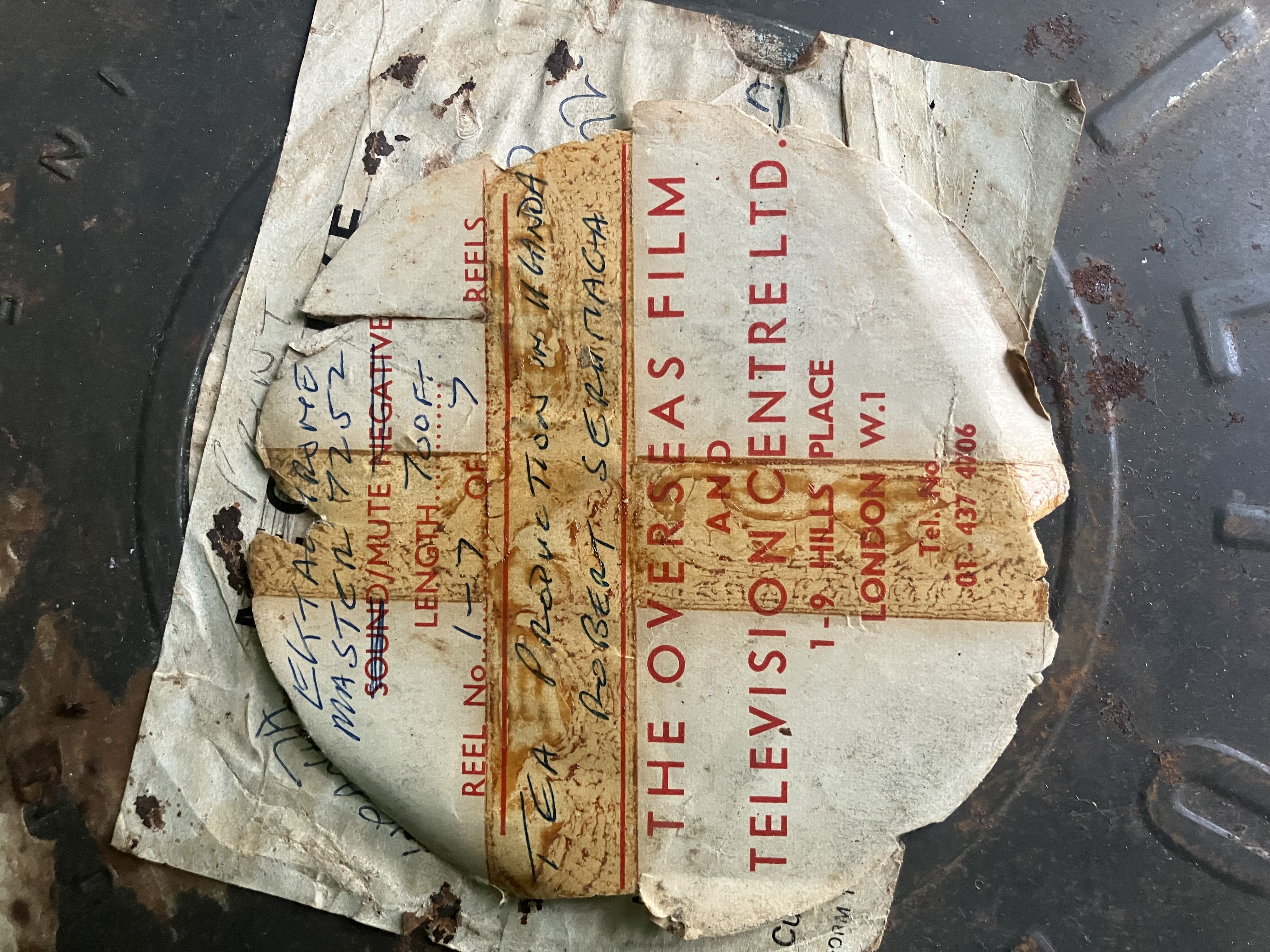 Paper with following text, describing film within: Reel 1-7 of 7 Reels. Tea production in Uganda, Robert Serumaga. The Overseas Film and Television Centre LTD. 1-9 Hills Place London W.1