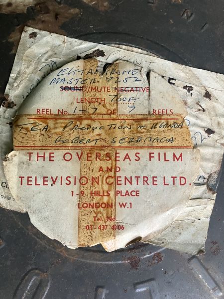 Paper with following text, describing film within: Reel 1-7 of 7 Reels. Tea production in Uganda, Robert Serumaga. The Overseas Film and Television Centre LTD. 1-9 Hills Place London W.1