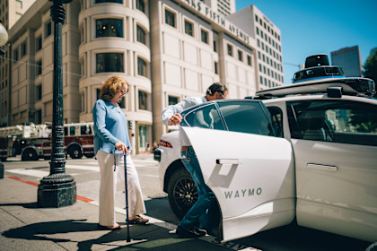 Cindy and Brian Hoeflinger entering a Waymo autonomous vehicle