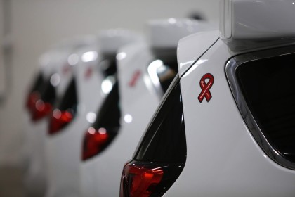 A photo of red ribbons on the side of white, Waymo Pacifica minivans