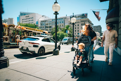 Hoeflinger family waving to a Waymo autonomous vehicle passing by