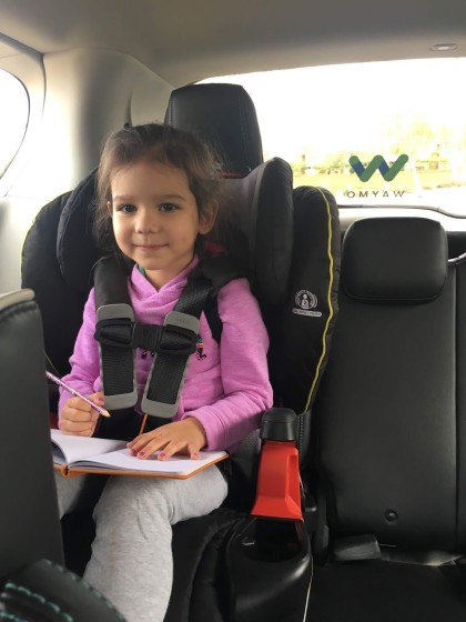 A photo of a toddler in a car seat in a Waymo vehicle