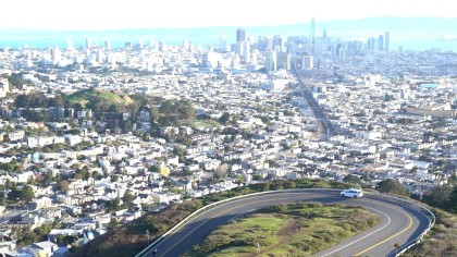 A photo of a white, Waymo Pacifica minivan driving in San Francisco 