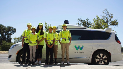 A photo of students visiting Waymo's closed course testing facility in neon-yellow safety gear