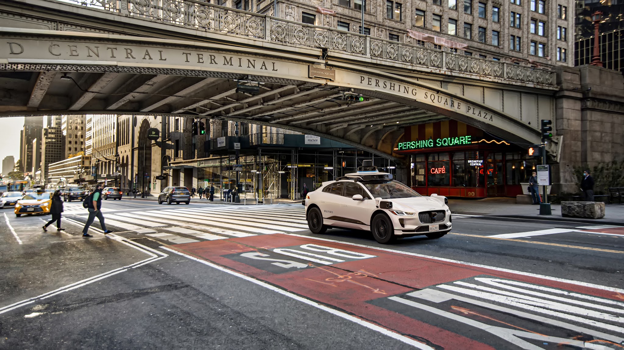A white Waymo Vehicle driving under the Park Avenue Viaduct in New York City 