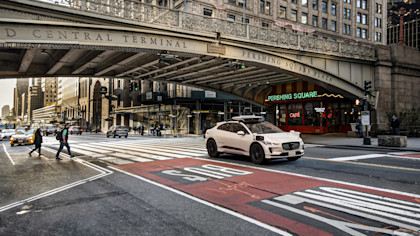 A white Waymo Vehicle driving under the Park Avenue Viaduct in New York City 