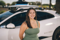 Hope standing in front of Waymo vehicle