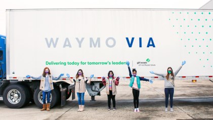 Five Girl Scouts stand in front of a Waymo Via truck 