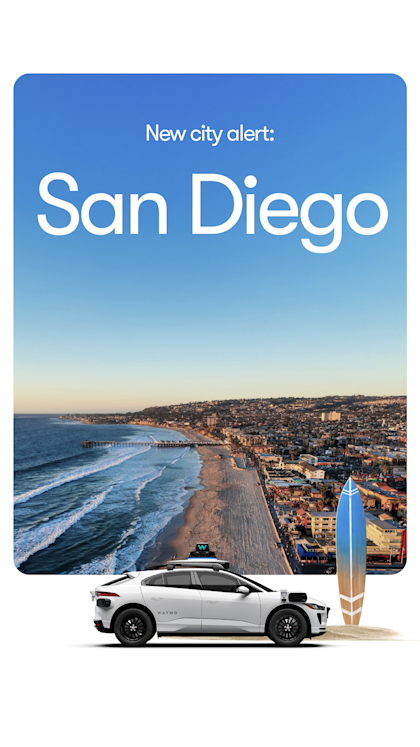 A white Waymo SUV in front of the San Diego skyline 