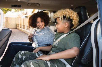 A photo of Waymo One rider, Samantha, with a kid in the back of a Waymo vehicle