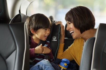 A photo of a parent and child in the back of a Waymo One vehicle