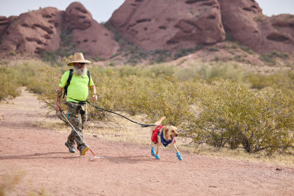 Rob and his Yellow Labrador guide dog, Kent, running on a trail through the Arizona desert