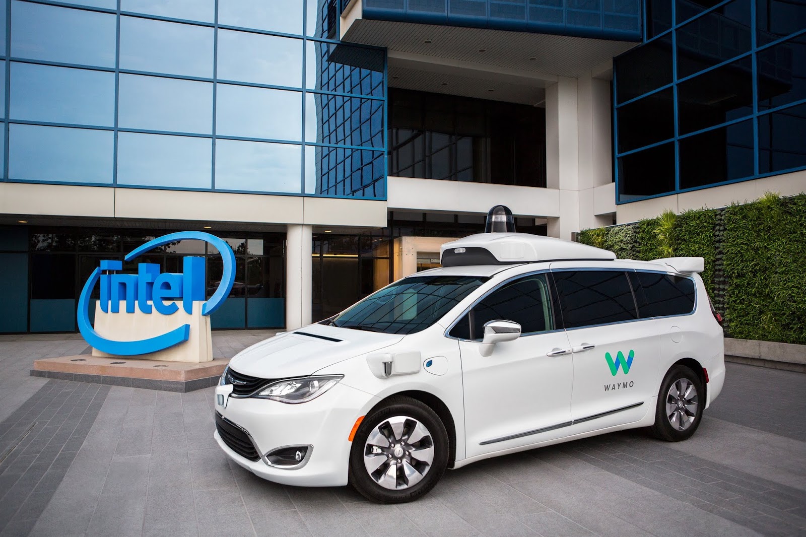 A white, Waymo Pacifica minivan in front of Intel's office