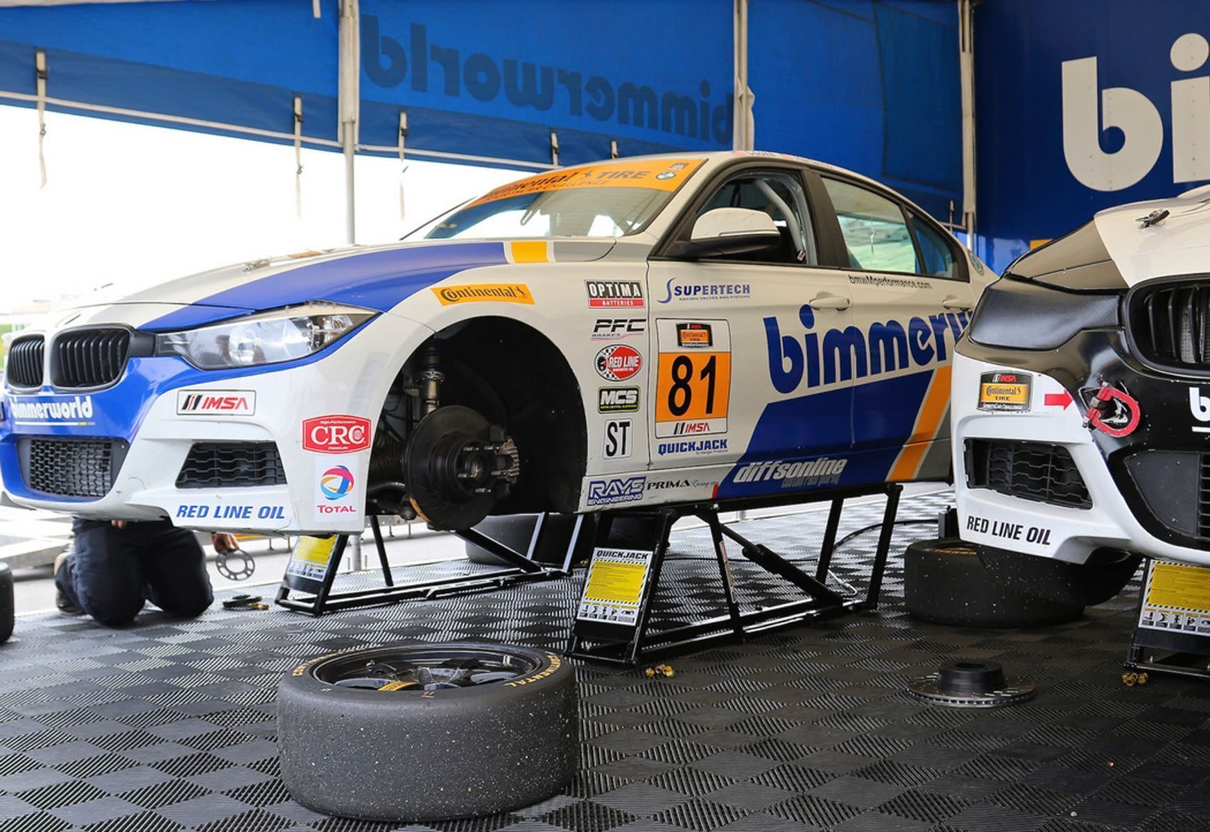 BimmerWorld Race Car On QuickJack Lift In Paddock