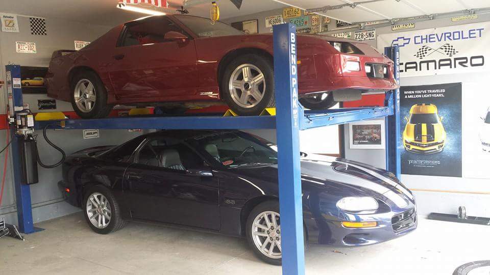 BendPak Four Post Lift Garage Storage With Two Muscle Cars