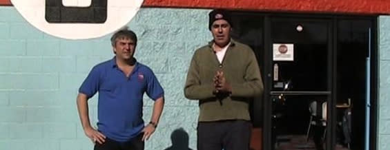 CarCast Hosts Standing Outside Automotive Shop Entrance