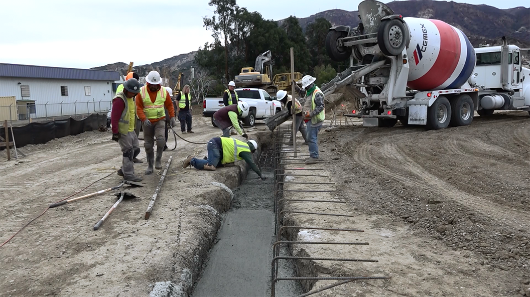Construction Crew Pouring Concrete Foundation for Industrial Facility
