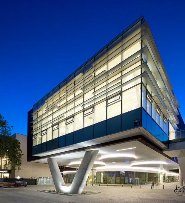 An office building designed by Dialog lit up at night.
