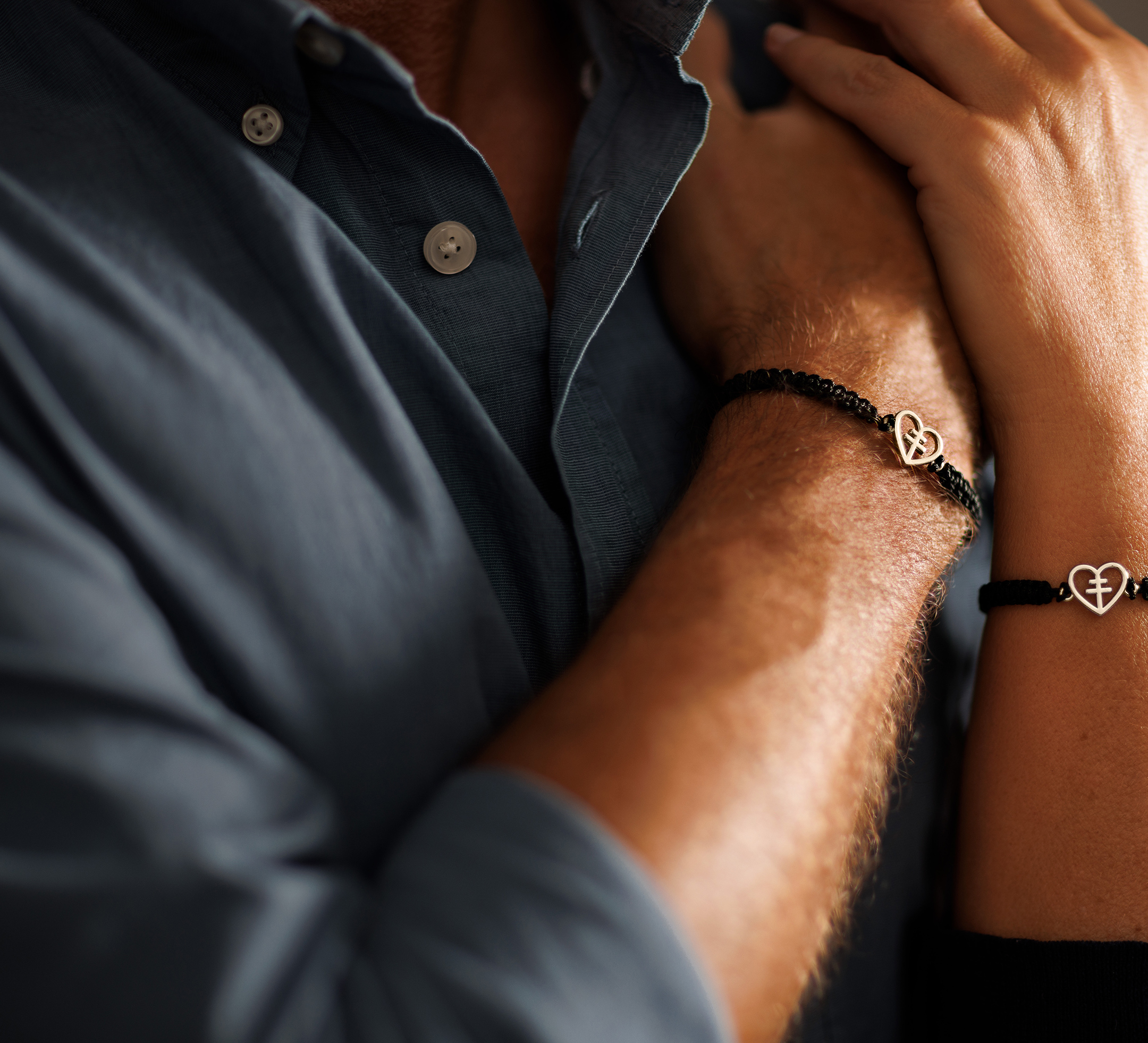 Närbild på två armar med armband med guldhjärtan.