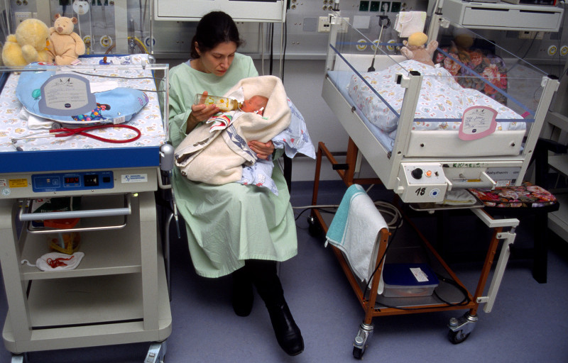 Kvinna matar bebis med nappflaska på sjukhus