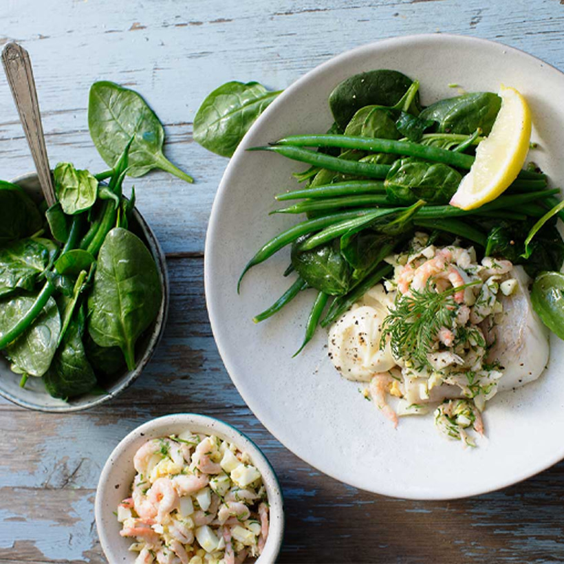 Kokt kolja med sallad på ett fat.
