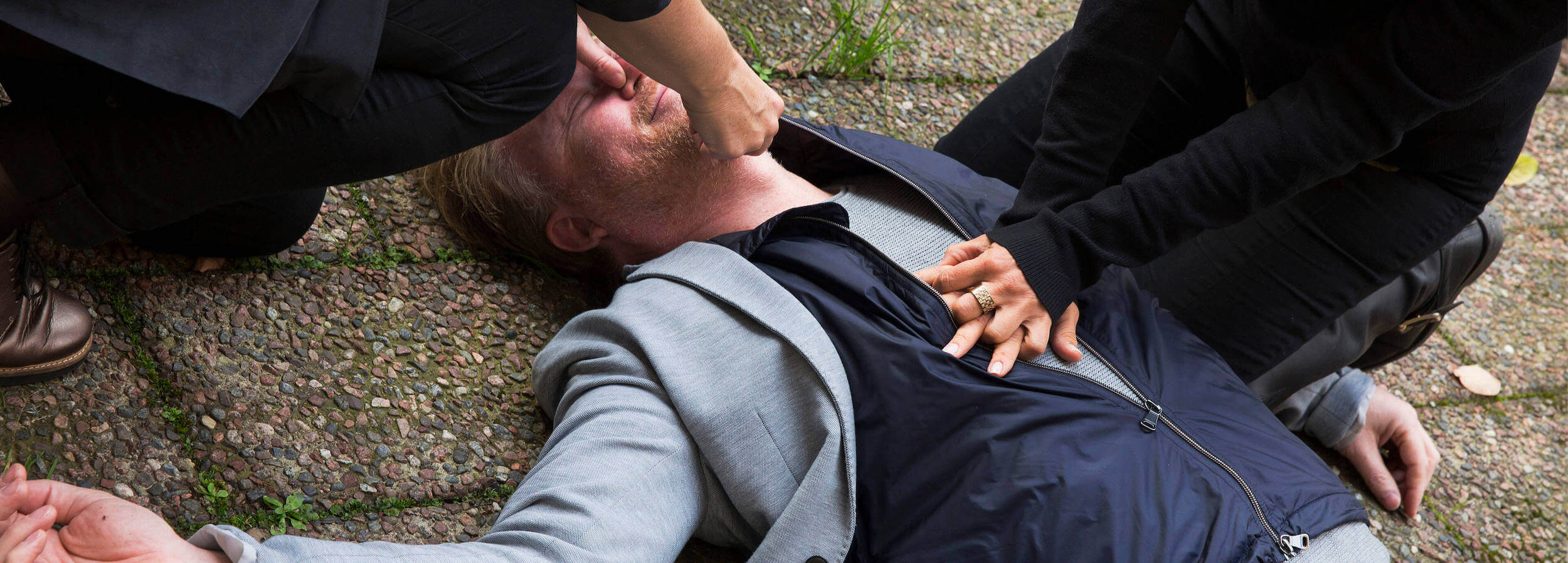 Man som ligger utomhus och får hjärt-lungräddning
