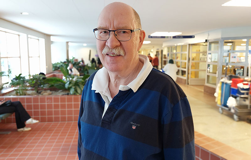 Tomas Sandström i en korridor med en blårandig tröja.