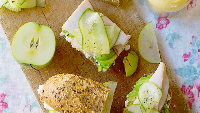 Smörgås med avokado och kalkon serverade på en skärbräda