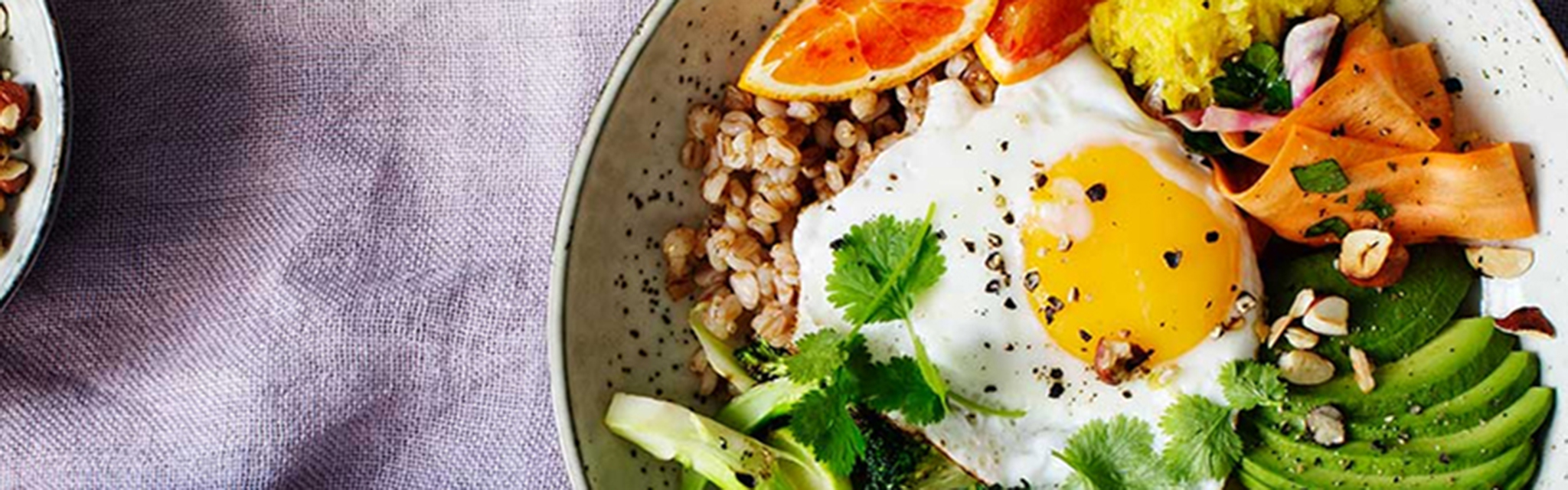 Broccolibowl med ägg på ett dukat bord.