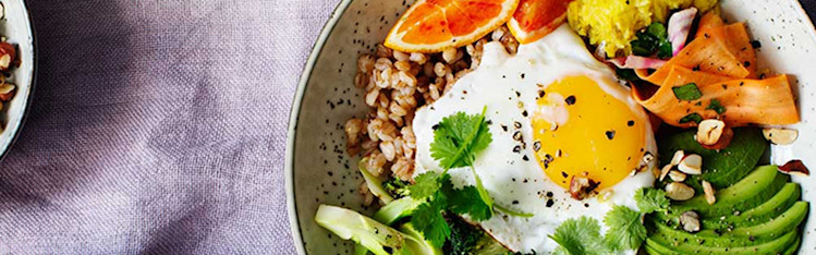 Broccolibowl med ägg på ett dukat bord.