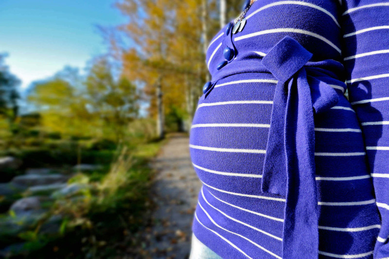 Gravid kvinna vid en skogsväg