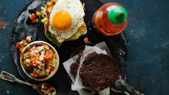 Bönburgare med tillbehör serverat på en tallrik.