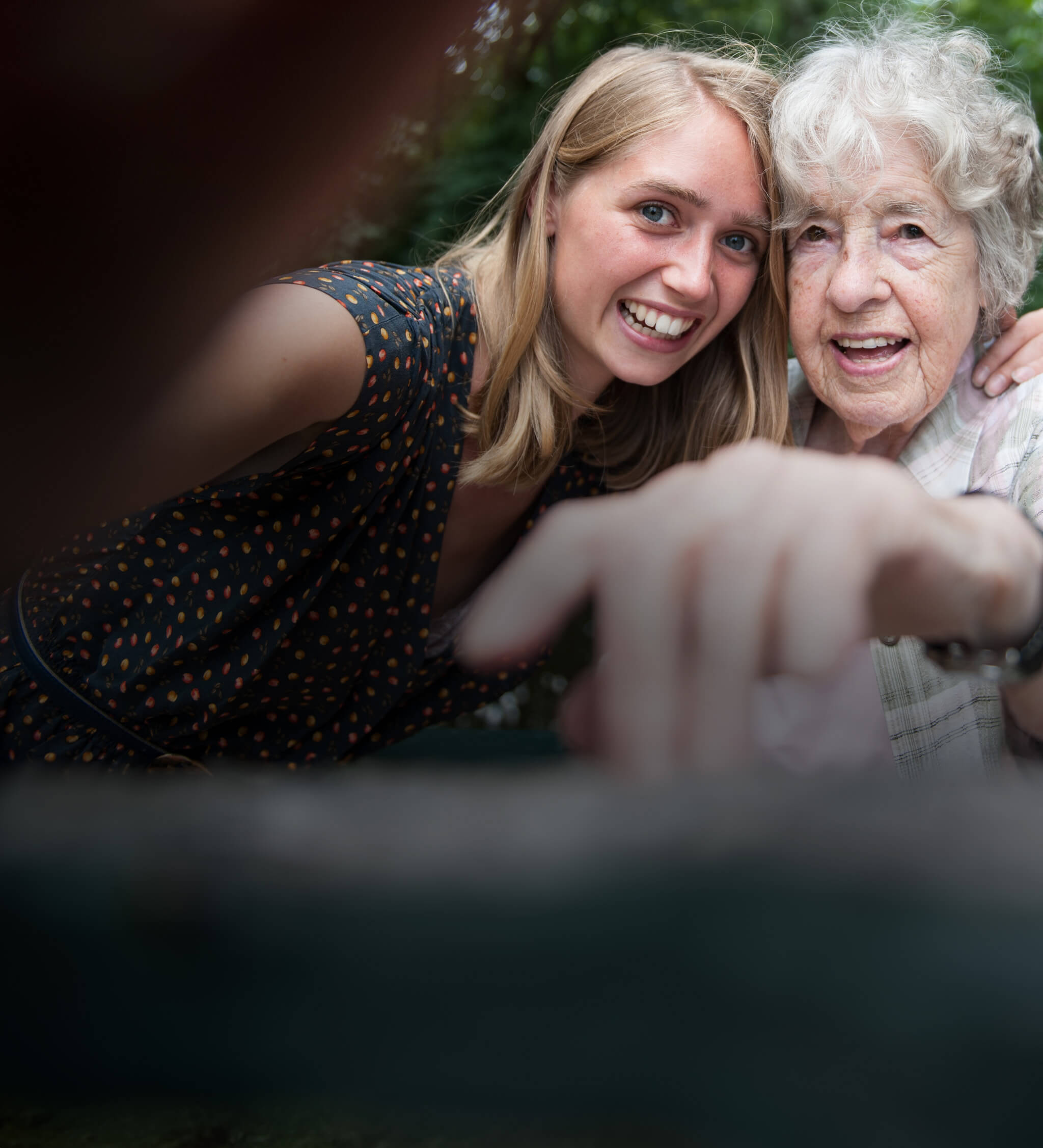 Äldre och yngre kvinna ler tillsammans.