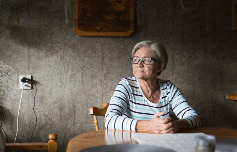 Kvinna sittande vid köksbord.