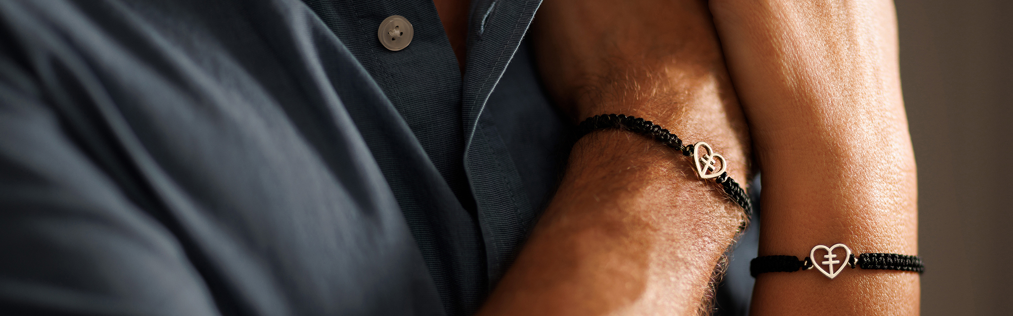 Närbild på två armar med Hjärt-Lungfondens guldarmband.