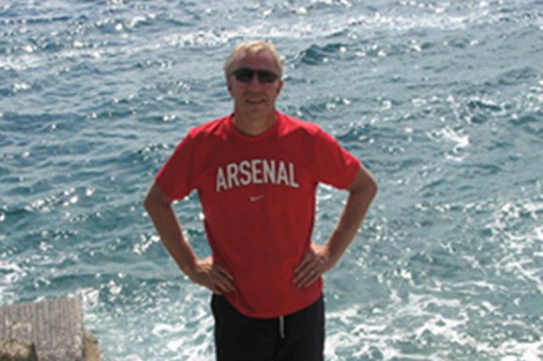 Man i röd t-tröja framför ett hav