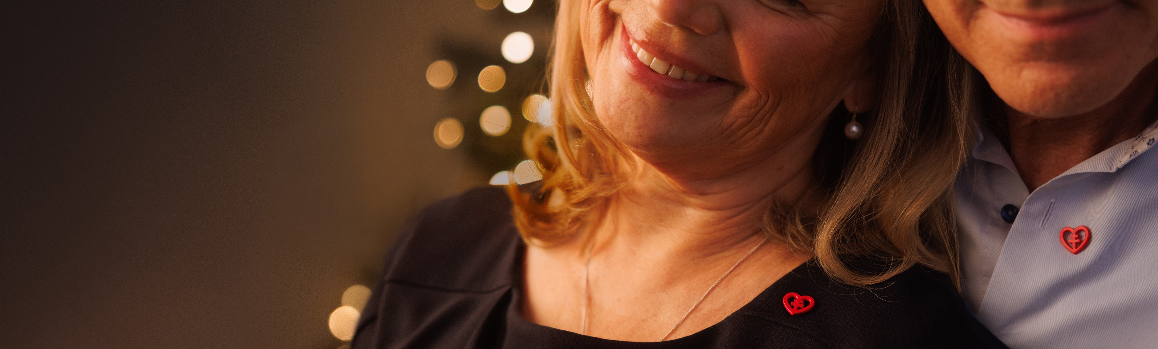 Par håller om varandra och båda har hjärtpin på sina tröjor