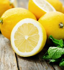 Hela och delade citroner på ett bord