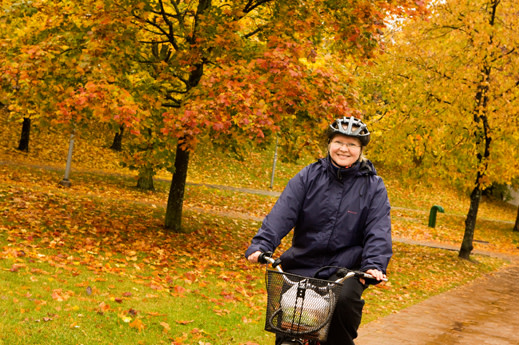 Kvinna på cykel i höstmiljö