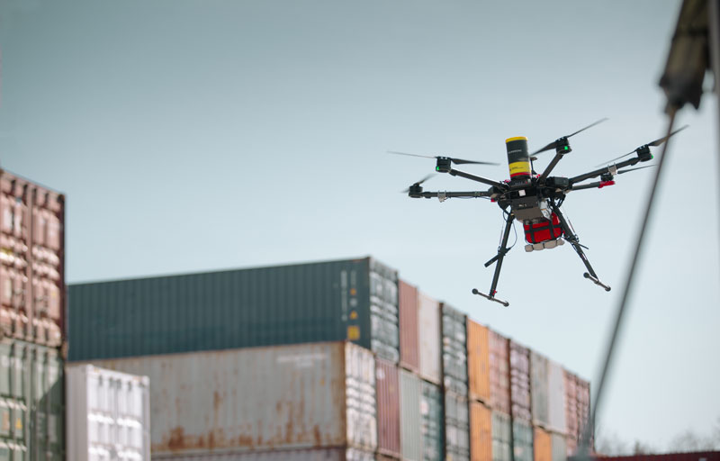 Drönare som flyger ovanför industriområde.