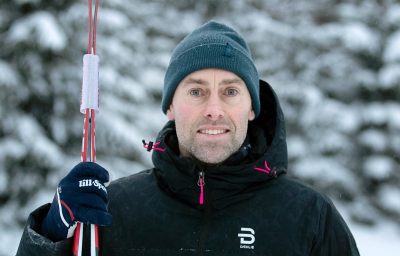 Jörgen Brink står i snön med ett par skidor i handen