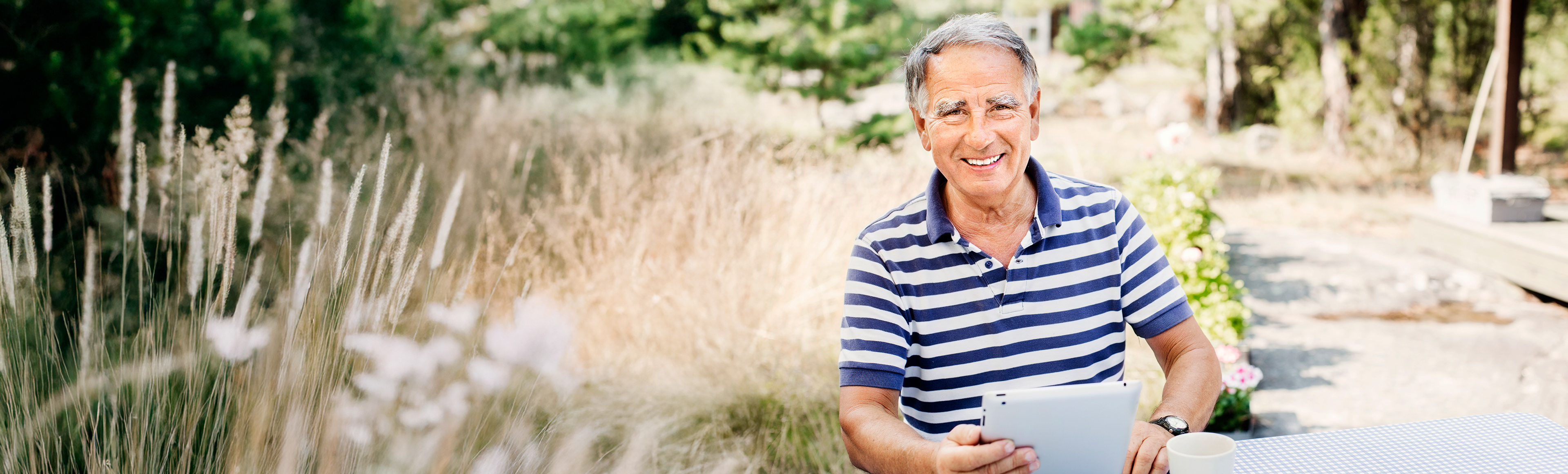 Man i trädgård i randig tröja.