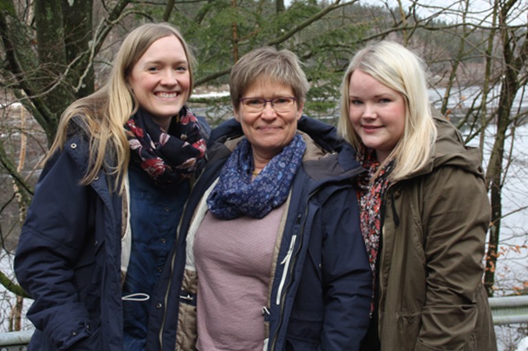 Kvinna med två yngre kvinnor i vintrig utomhusmiljö