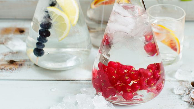 Olika bär i Erlenmeyerkolvar fyllda med vatten.